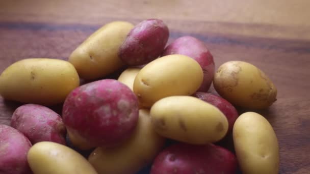 自宅のキッチンで木の板に有機の赤ちゃんのジャガイモを準備する人の手 — ストック動画
