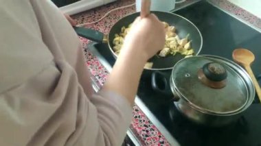 Eletric sobada tavuk kızartan genç bayanı kapatın.