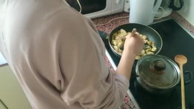 Eletric sobada tavuk kızartan genç bayanı kapatın.