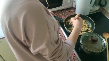 Eletric sobada tavuk kızartan genç bayanı kapatın.