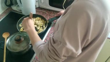 Eletric sobada tavuk kızartan genç bayanı kapatın.