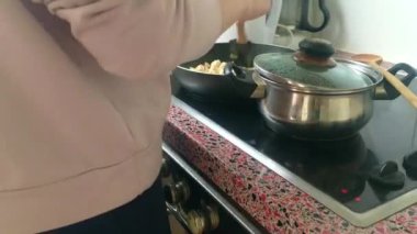 Eletric sobada tavuk kızartan genç bayanı kapatın.