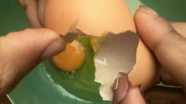 Evde omlet için bir kasede yumurta hazırlayan insan elleri