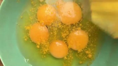 Evde omlet için bir kasede yumurta hazırlayan insan elleri