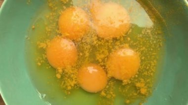 Evde omlet için bir kasede yumurta hazırlayan insan elleri