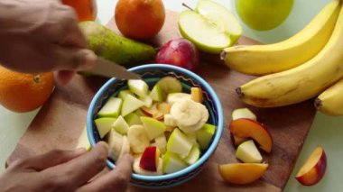 Yakın çekim şefi evde sağlıklı meyve salatası hazırlıyor.