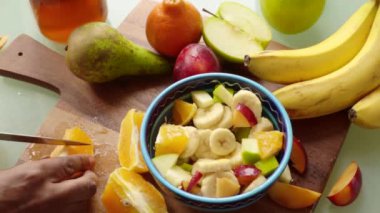 Yakın çekim şefi evde sağlıklı meyve salatası hazırlıyor.