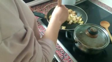 Eletric sobada tavuk kızartan genç bayanı kapatın.