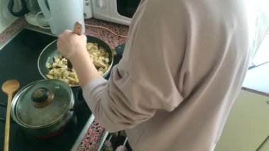 Eletric sobada tavuk kızartan genç bayanı kapatın.