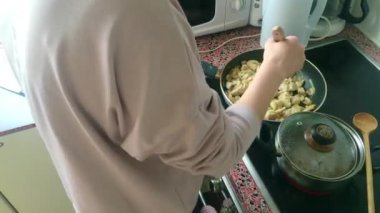 Eletric sobada tavuk kızartan genç bayanı kapatın.