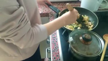 Eletric sobada tavuk kızartan genç bayanı kapatın.