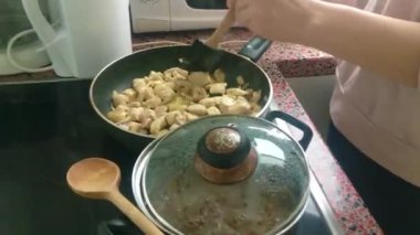 Eletric sobada tavuk kızartan genç bayanı kapatın.