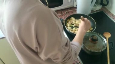 Eletric sobada tavuk kızartan genç bayanı kapatın.