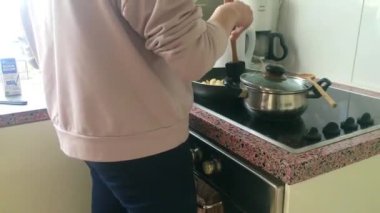 Eletric sobada tavuk kızartan genç bayanı kapatın.