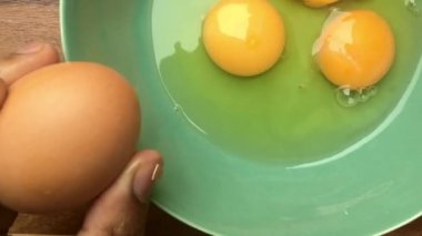 Evde omlet için bir kasede yumurta hazırlayan insan elleri