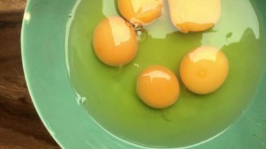 Evde omlet için bir kasede yumurta hazırlayan insan elleri