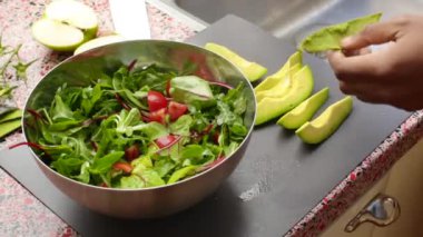 Evde taze ve organik sebze salatası hazırlayan kişiyi yakından çek.