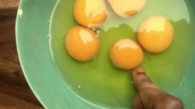 Evde omlet için bir kasede yumurta hazırlayan insan elleri