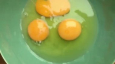 Evde omlet için bir kasede yumurta hazırlayan insan elleri