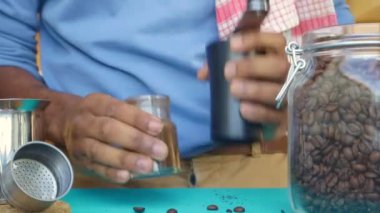 Moka pot için kavrulmuş kahve çekirdeği öğüten kişi.