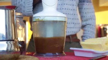 Yetişkinlerin evde tereyağlı ketojenik kurşun geçirmez kahve yapmasına yakın çekim.