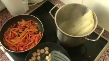 Evde fırında karides kızartan genç yetişkinler.