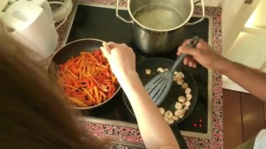 Evde fırında karides kızartan genç yetişkinler.