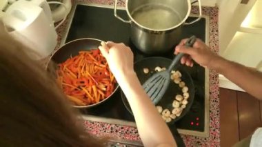 Evde fırında karides kızartan genç yetişkinler.