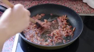 Mutfakta Carbonara makarnası için domuz pastırması kızartıyorum.