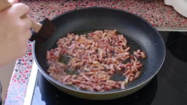 Mutfakta lezzetli carbonara makarnası için domuz pastırması kızartma şefini kapat.