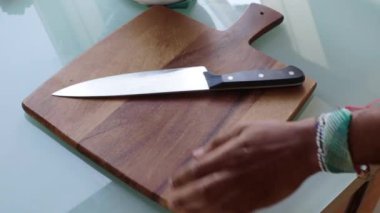 Ahşap kesim tahtasında sebze hazırlayan insanlar.