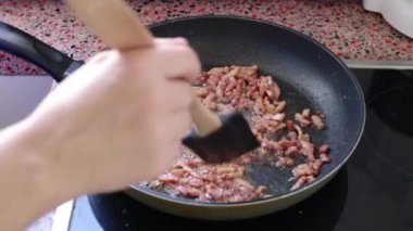 Carborana için domuz pastırması kızartıyorum. 