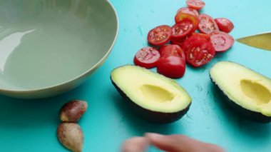 Avokadoyu mutfakta vejetaryen yemeğine hazırlayan kişi.
