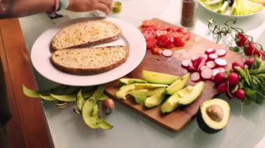 Evde sağlıklı tartinli sandviç yapan kişi.