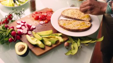 Evde sağlıklı tartinli sandviç yapan kişi.