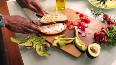 Evde sağlıklı tartinli sandviç yapan kişi.