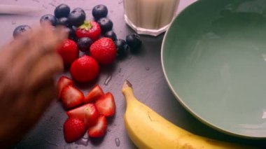 Elleri ahşap kesim tahtasında meyve hazırlıyor.