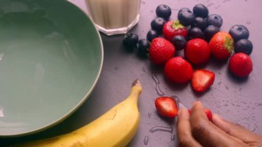 Elleri ahşap kesim tahtasında meyve hazırlıyor.