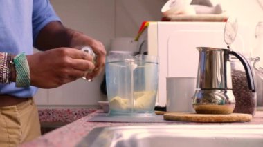 Person making bulletproof coffee with butter and MCT oil at home 