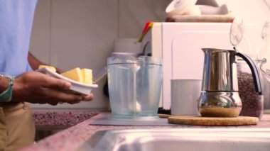 Person making bulletproof coffee with butter and MCT oil at home 