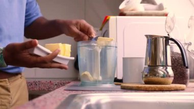 Kahvaltıda evde tereyağlı kurşun geçirmez kahve yapan kişi.