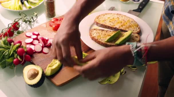 健康的なビーガンタルティーヌサンドイッチを作る人のトップビュー — ストック動画