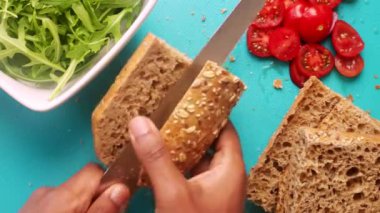 Avokado domatesli tartinli sandviç yapan düz biri.