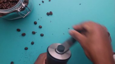 90 degree of person manually grinding roasted coffee beans at home 
