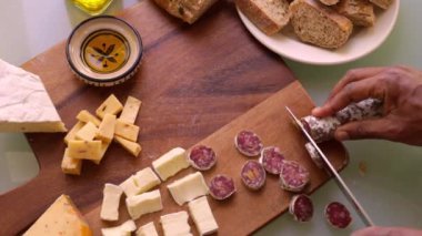 Ahşap tahtayı aperatiflerle hazırlayan şefin üst görüntüsü.