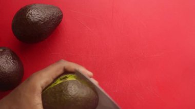 Kesme tahtasında avokado hazırlayan kişinin üst görünümü