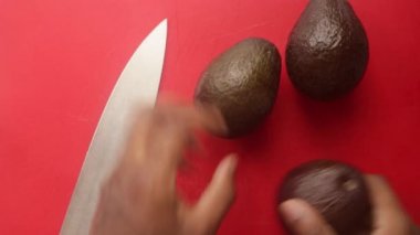 Avokadoları doğrama tahtasında hazırlayan kişinin üst görünümü