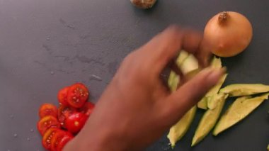 close-up of person hands preparing avocado and cherry tomatoes                 