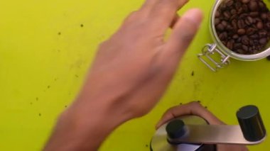 90 derecelik kişi elle kavrulmuş kahve çekirdeğini öğütüyor.