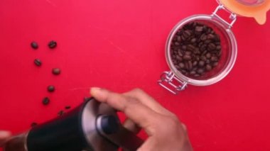 Düz biri mutfaktaki kahve çekirdeklerini elle öğütüyor.